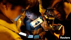 지난 28일 베트남 하노이 멜리아호텔 밖에서 기자들이 리용호 북한 외무상의 긴급기자회견을 스마트폰으로 시청하고 있다.