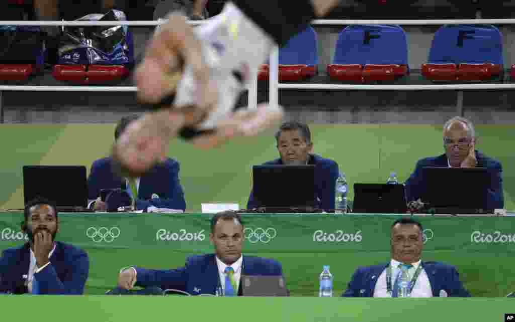 Judges watch Germany's Andreas Bretschneider perform his floor routine during the artistic gymnastics men's qualification at the 2016 Summer Olympics in Rio de Janeiro, Brazil, Aug. 6, 2016.