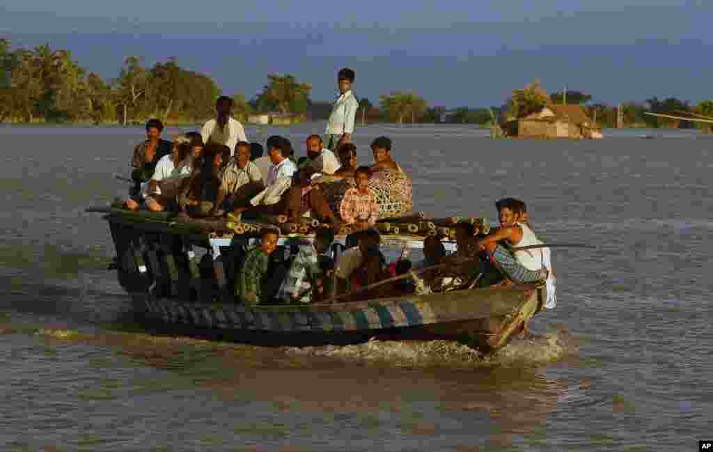 D&acirc;n l&agrave;ng bị ảnh hưởng v&igrave; lũ lụt chen ch&uacute;c tr&ecirc;n một chiếc thuyền tại l&agrave;ng Gagalmari, bang Assam, ng&agrave;y 2 th&aacute;ng 7 năm 2012