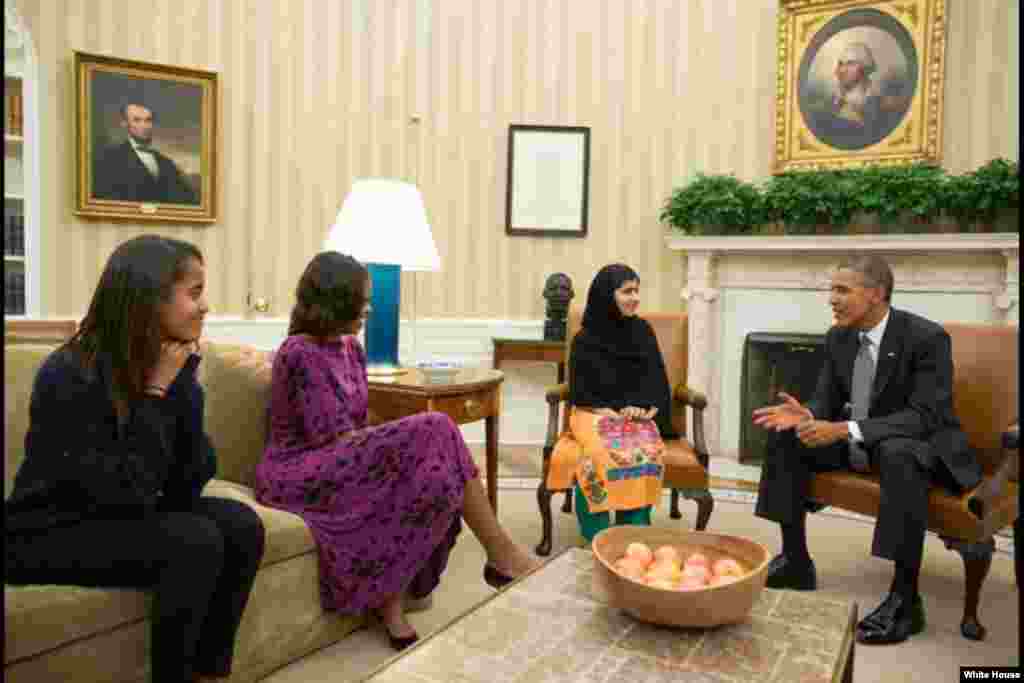 President Barack Obama, First Lady Michelle Obama, and their daughter Malia meet with Malala Yousafzai, the young Pakistani schoolgirl who was shot in the head by the Taliban a year ago, in the Oval Office, Washington, D.C.