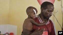 Abdulle Ibrahim, holds his son Adam Ibrahim at the International Rescue Committee, IRC, clinic in the town of Dadaab, Kenya, July 29, 2011.