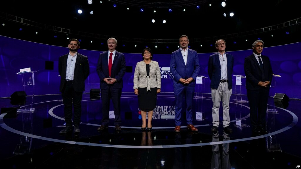 Chilean presidential candidates, from left, Gabriel Boric, Jose Antonio Kast, Yasna Provoste, Sebastián Sichel, Eduardo Artes, and Marco Henriquez-Ominami, pose for a photo prior to the presidential debate in Santiago, Chile, Nov. 15, 2021. (AP Photo/Esteban Felix, Pool)