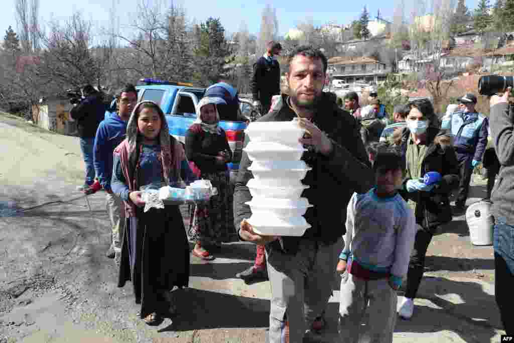 Metropolitan Municipality workers hand out food to a community in Ankara, Turkey, as part of measures taken to prevent the spread of the COVID-19 disease caused by the new coronavirus.