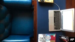 This Feb 27, 2020, photo released by Louis Wang, shows his work desk with laptop and textbooks at home in northeast China. Wang is a middle school history teacher in northeast China. (Louis Wang via AP)