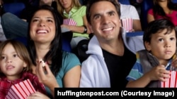 Hispanic family enjoying popcorn at movie theater