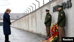 Thủ tướng Đức Angela Merkel đặt vòng hoa đánh dấu 70 năm ngày giải phóng một khu trại từng được Đức quốc xã sử dụng. 