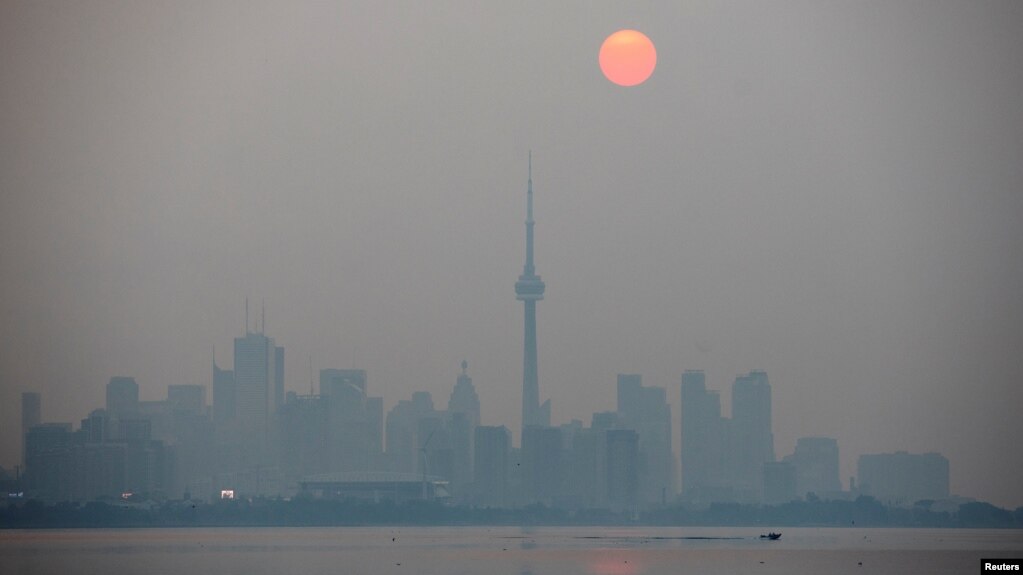 The sun rises through a cover of wildfire smoke above the CN Tower and downtown skyline in Toronto, Ontario, Canada July 20, 2021. (REUTERS/Carlos Osorio)