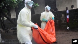 Petugas kesehatan mengangkut jenazah korban tewas akibat ebola di New Kru Town, pinggiran Monrovia, Liberia (8/10).