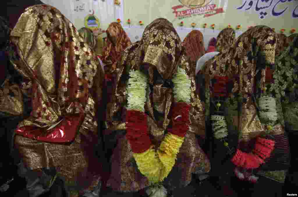 Brides sit together during a mass wedding ceremony in Peshawar. A total of 25 couples from Pakistan's northwest province of Khyber Pakhtunkhwa participated in the ceremony, organized by Al-Khidmat Foundation.