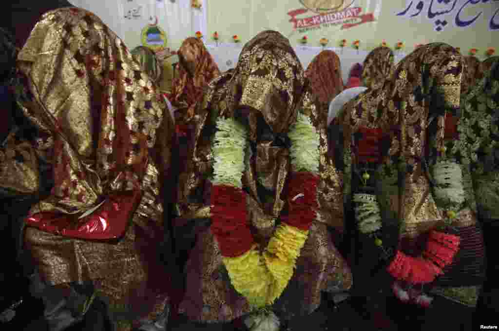 Brides sit together during a mass wedding ceremony in Peshawar. A total of 25 couples from Pakistan&#39;s northwest province of Khyber Pakhtunkhwa participated in the ceremony, organized by Al-Khidmat Foundation.