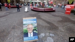 A placard with the face of Australian Prime Minister Scott Morrison is placed near the entrance of Town Hall as voters line up to cast their ballots in a federal election Sydney, Australia, May 18, 2019.