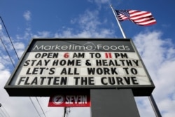 A neighborhood market marquee reads "stay home and healthy, lets all work to flatten the curve" in Seattle, Washington, U.S. April 2, 2020. (REUTERS/Jason Redmond)