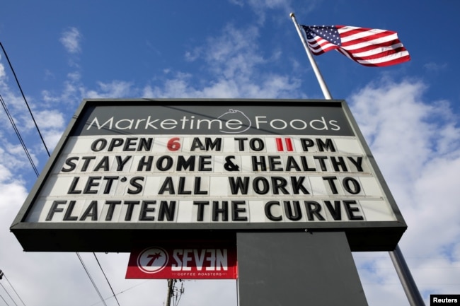 A neighborhood market marquee reads "stay home and healthy, lets all work to flatten the curve" in Seattle, Washington, U.S. April 2, 2020. (REUTERS/Jason Redmond)