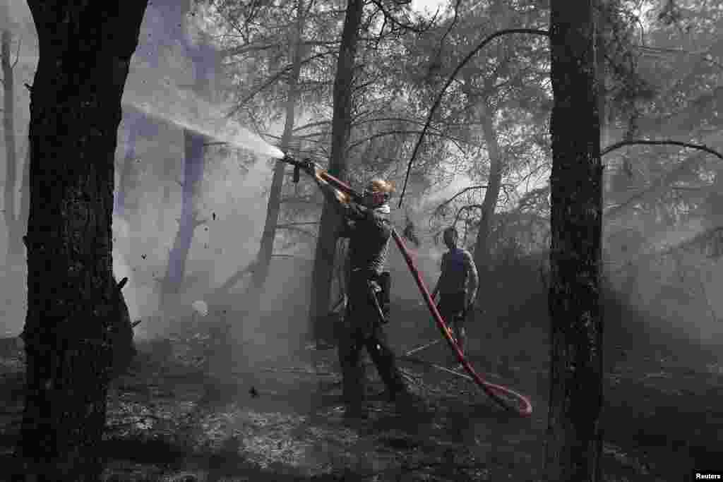 Volunteer firefighters extinguish a forest fire in Kareas suburb, east of Athens, Greece.