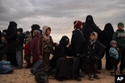 Women and children evacuated out of the last territory held by Islamic State militants wait to be screened by U.S.-backed Syrian Democratic Forces in the desert outside Baghuz, Syria, Feb. 27, 2019.