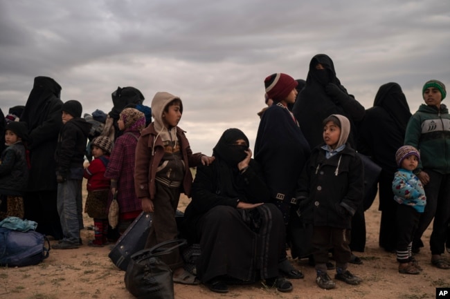 Women and children evacuated out of the last territory held by Islamic State militants wait to be screened by U.S.-backed Syrian Democratic Forces in the desert outside Baghuz, Syria, Feb. 27, 2019.