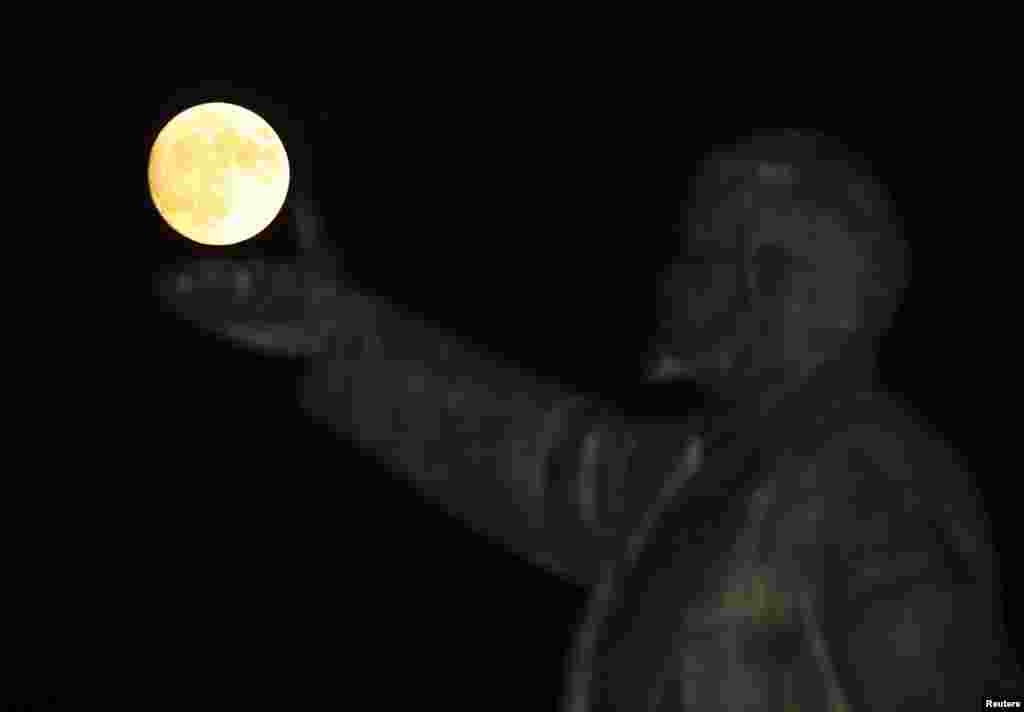 A full moon rises behind a statue of Soviet state founder Vladimir Lenin on the eve of the &quot;supermoon&quot; spectacle, Baikonur, Kazakhstan.