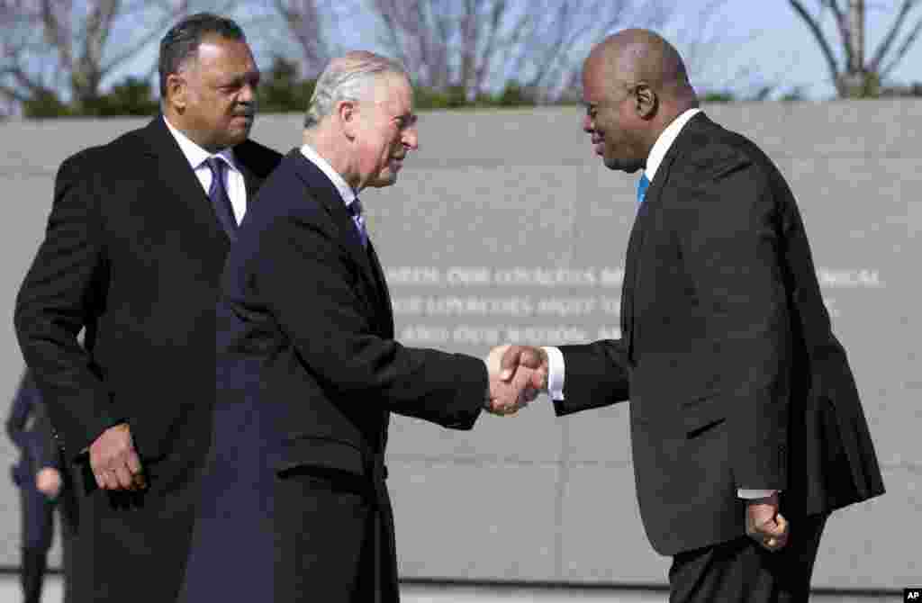 O Príncipe Charles, com o Reverendo Jesse Jackson, no memorial de Martin Luther King, ao lado de quem Jackson lutou pelos direitos iguais nos Estados Unidos, e aperta a mão de Harry E. Johnson, CEO da fundação que mantém o memorial. &nbsp;