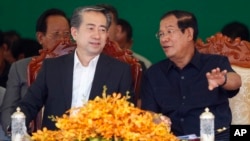 Cambodian Prime Minister Hun Sen, right, talks with Chinese Ambassador to Cambodia Xiong Bo, front left, during an inauguration ceremony of a sky bridge funded by China in Phnom Penh, July 2, 2018. 