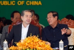 Cambodian Prime Minister Hun Sen, right, talks with Chinese Ambassador to Cambodia Xiong Bo, front left, during an inauguration ceremony of a sky bridge funded by China in Phnom Penh, Cambodia, July 2, 2018.