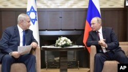 Russian President Vladimir Putin, right, and Israeli Prime Minister Benjamin Netanyahu speak during their meeting in Sochi, Russia, Aug. 23, 2017. 