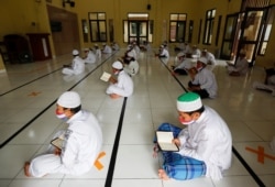 Siswa Muslim mengenakan masker wajah di tengah penyebaran COVID-19, saat membaca Alquran di Masjid Al-Kautsar Daarul Qur'an selama bulan suci Ramadhan, di Bogor, Jawa Barat, 9 Mei 2020 . (Foto: Reuters/Willy Kurniawan)