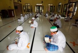 Siswa Muslim mengenakan masker dan menjaga jarak aman, saat membaca Alquran di Masjid Al-Kautsar Daarul Qur'an selama bulan suci Ramadhan tahun lalu, di Bogor, Jawa Barat. (Foto: Reuters/Willy Kurniawan)