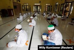 Siswa Muslim mengenakan masker dan menjaga jarak aman, saat membaca Alquran di Masjid Al-Kautsar Daarul Qur'an selama bulan suci Ramadhan tahun lalu, di Bogor, Jawa Barat. (Foto: Reuters/Willy Kurniawan)