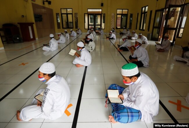 Siswa Muslim mengenakan masker dan menjaga jarak aman, saat membaca Alquran di Masjid Al-Kautsar Daarul Qur'an selama bulan suci Ramadhan tahun lalu, di Bogor, Jawa Barat. (Foto: Reuters/Willy Kurniawan)