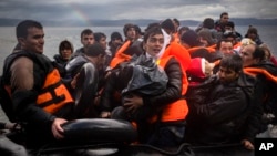 Refugees and migrants arrive on a beach after crossing a part of the Aegean sea from the Turkey's coast to the Greek island of Lesbos, Nov. 28, 2015.