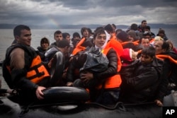 Refugees and migrants arrive on a beach after crossing a part of the Aegean sea from the Turkey's coast to the Greek island of Lesbos, Nov. 28, 2015.