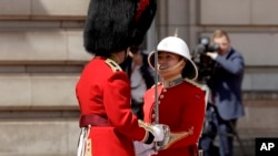 Canadian Captain Megan Couto, right, makes history by becoming the first female Captain of the Queen's Guard as she takes part in the Changing the Guard ceremony at Buckingham Palace in London, Monday, June 26, 2017. (AP Photo/Matt Dunham)