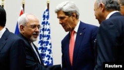 FILE - U.S. Secretary of State John Kerry, right, shakes hands with Iranian Foreign Minister Mohammad Javad Zarif, United Nations, Geneva, Nov. 24, 2013.