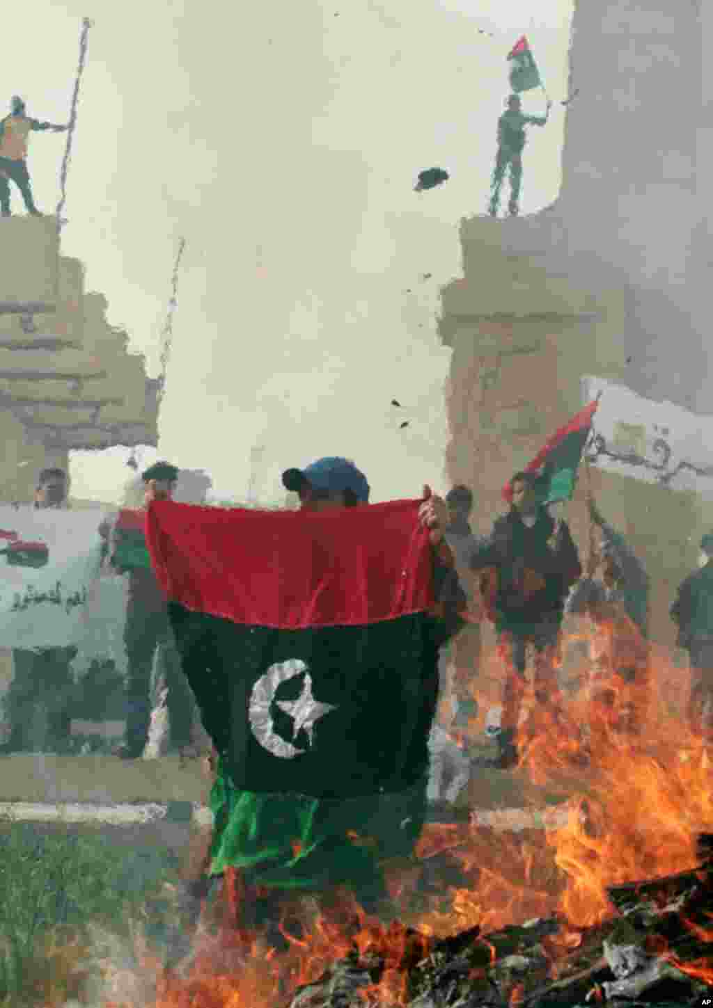 Protesters burn pictures of Gaddafi and copies of the Green Book. (Reuters/Suhaib Salem)