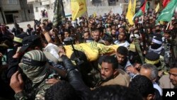 Anggota keluarga dan militan Palestina bertopeng mengusung jenazah Hamdan Abu Amsha, 23, dalam acara pemakamannya di Beit Hanoun, Jalur Gaza, 31 Maret 2018 (foto: AP Photo/Adel Hana)