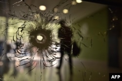 A bullet impact is pictured on a window in the entrance hall of a building on the Champs Elysees avenue in Paris, on April 21, 2017.