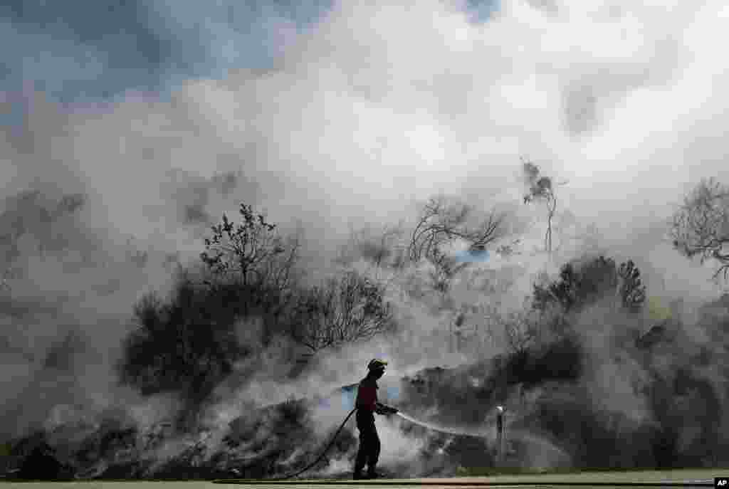 A Portuguese firefighter fights to extinguish a fire in Adsamo, near Vouzela, Portugal. More than 600 firefighters were battling six new wildfires a day after one firefighter was killed and nine others injured when gusting winds winds caused a fire to change direction.