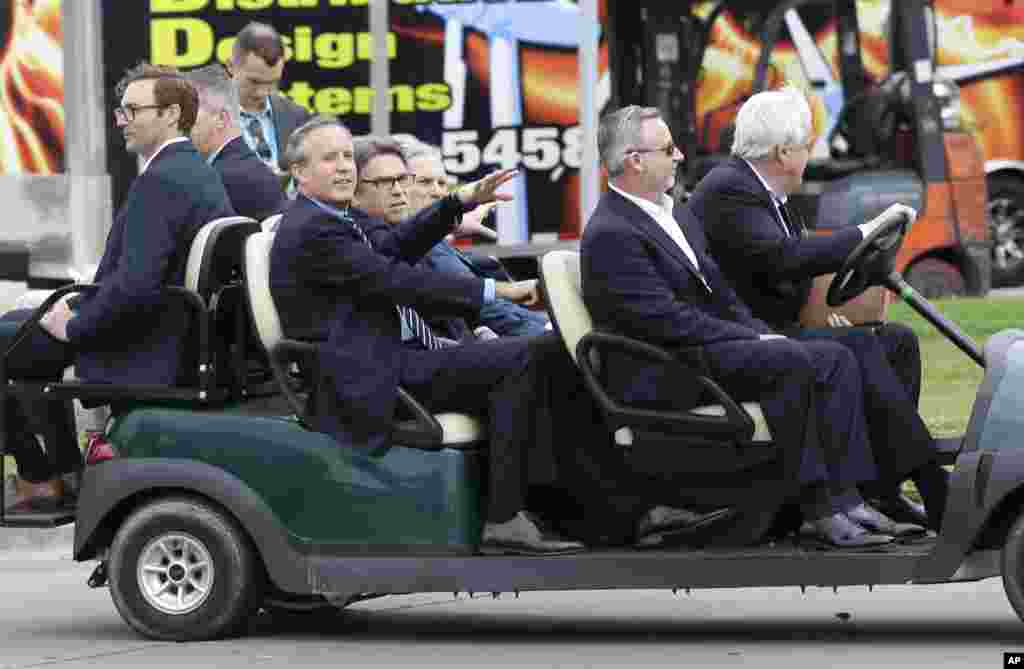 Menteri Energi AS Rick Perry, tengah kiri, berbicara dengan Jaksa Agung Texas Ken Paxton di atas mobil golf ketika berkeliling melihat pameran Hari Bumi di Fair Park di Dallas, 21 April 2017.