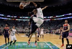 Boston Celtics forward Jaylen Brown (7) dunks over Washington Wizards guard Bojan Bogdanovic during the fourth quarter of Game 7 of a second-round NBA basketball playoff series, May 15, 2017, in Boston.