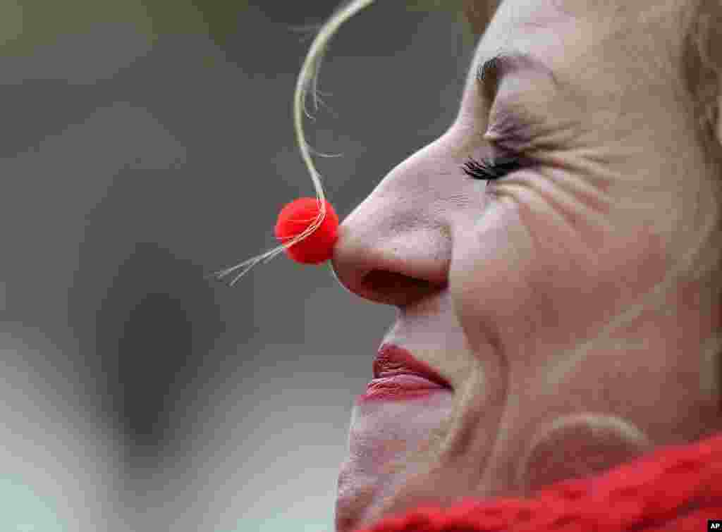 A reveller with a tiny red nose celebrates the start of the carnival season in the streets of Cologne, Germany.