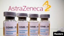 Vials with a sticker reading, "COVID-19 / Coronavirus vaccine / Injection only" and a medical syringe are seen in front of a displayed AstraZeneca logo in this illustration taken October 31, 2020. REUTERS/Dado Ruvic/Illustration/File Photo