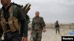 FILE - Kurdish Peshmerga fighters search for Islamic State militants in Telskuf, northern Iraq, May 4, 2016.