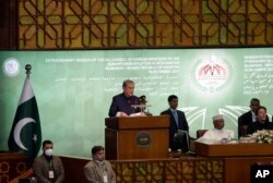 Pakistani Foreign Minister Shah Mahmood Qureshi, center, speaks during the 17th extraordinary session of Organization of Islamic Cooperation (OIC) Council of Foreign Ministers, in Islamabad, Pakistan, Dec. 19, 2021.