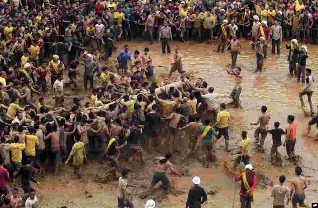 Homens da tribo Jaintia transportam uma árvore sagrada durante o festival Behdienkhlam em Jowai, no nordeste da Índia, estado de Meghalaya. O Behdienkhlam é um festival tradicional que acontece depois dos Jaintia semearem a terra. Eles celebram para pedir boas colheitas e para afastar pragas e doenças. Os jovens afastam simbolicamente os maus espíritos batendo nos telhados de todas as casas com paus de bambu.