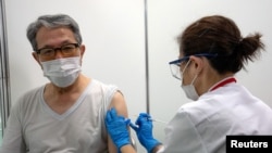 Một người cao tuổi được tiêm vaccine ngừa COVID-19 tại trung tâm tiêm chủng đại trà mới mở vào ngày 24/5/2021 tại Tokyo, Nhật Bản.