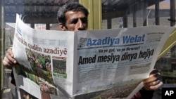 A man reads a Kurdish newspaper in southeastern city of Diyarbakir, Turkey, March 22, 2009.