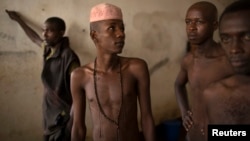 Men stand in a cell block for Muslim detainees, who are separated from the rest of the Christian inmates, at the central prison in the district of Wango, in the capital Bangui, March 21, 2014. 