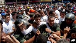Lãnh đạo đối lập Venezuela Leopoldo Lopez (áo trắng) tự nộp mình cho lực lượng an ninh tại Caracas, ngày 18/2/2014.