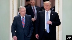 President Donald Trump accompanied by Senate Majority Leader Mitch McConnell of Kentucky, left, arrives for a Senate Republican Policy lunch on Capitol Hill in Washington, May 15, 2018. 