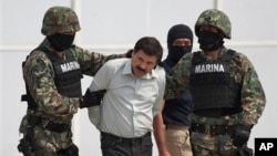 FILE - Joaquin "El Chapo" Guzman is escorted to a helicopter in handcuffs by Mexican navy marines at a navy hanger in Mexico City, Feb. 22, 2014. 